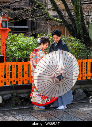 Coppia giovane indossando vestiti tradizionali, Shinbashi dori, Kyoto, Giappone Foto Stock