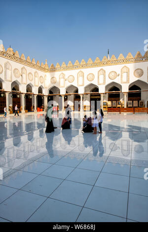 Le donne e i bambini a piedi attraverso il marmo cortile lastricato del dalla Moschea di Al Azhar al Cairo Foto Stock