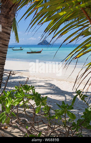 Longtail Boat presso la spiaggia Laemtong su Phiphi island, Thailandia. Sullo sfondo l'isola di zanzara. Foto Stock