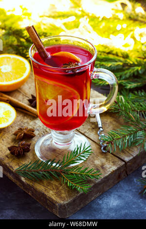 Vin brulé con spezie e albero di Natale su sfondo scuro. Foto Stock