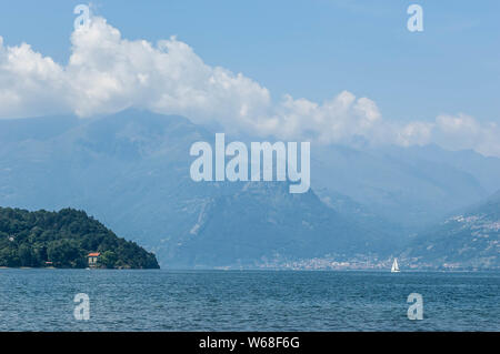 Vista del lago di montagna e il pomontory su una soleggiata giornata estiva. Distretto del Lago di Como, Colico, Italia, Europa. Foto Stock