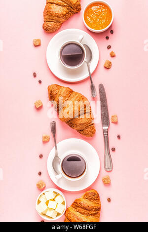 Caffè e Croissant su sfondo color pastello, vista dall'alto. Foto Stock