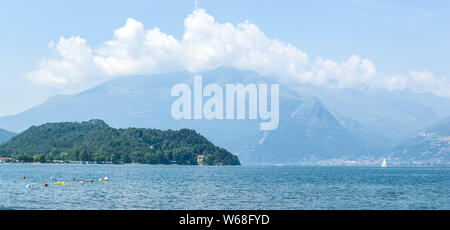 Vista panoramica del lago di montagna e il pomontory su una soleggiata giornata estiva. Distretto del Lago di Como, Colico, Italia, Europa. Foto Stock