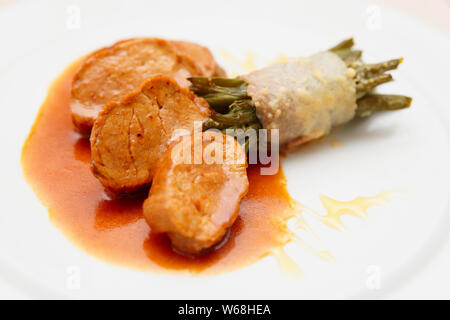 Filetto di maiale con profondo fritto fagiolini, close-up Foto Stock