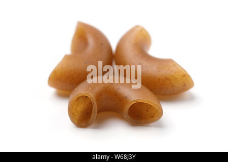 Pasta prodotta con farina di grano saraceno in forma di corna su sfondo bianco Foto Stock