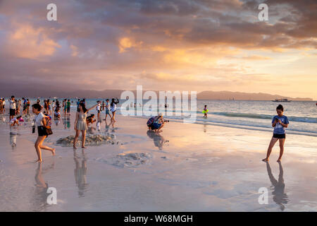 I turisti si riuniscono per guardare il tramonto sulla spiaggia bianca, Boracay, Aklan Provincia, Filippine Foto Stock