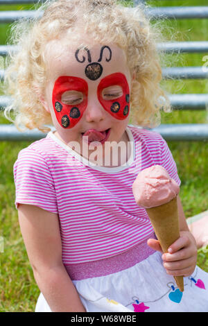 Brockenhurst, Hampshire, Regno Unito. Il 31 luglio 2019. Migliaia accorrono per la seconda giornata della nuova foresta & Hampshire County Show. Quattro anni di gemelli rosa e Robyn prendere una pausa per gustare un gelato. Credito: Carolyn Jenkins/Alamy Live News Foto Stock