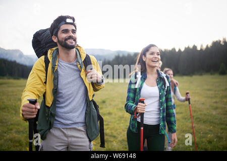 Backpackers felice coppia giovane escursionismo con bastoni Foto Stock