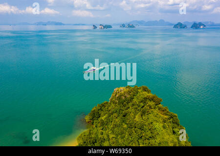 Un traghetto che passa la minuscola isola tropicale di Koh Nok nel Phanga Nga Bay area della Thailandia Foto Stock