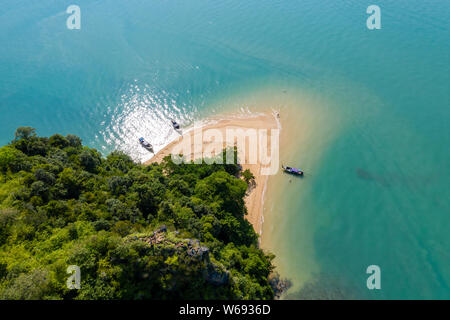 Antenna fuco vista delle barche longtail passando tra 2 piccole, rocky isole tropicali Foto Stock