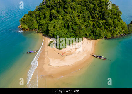 Top down vista aerea delle tradizionali barche longtail ormeggiato a una bella, tropicali piccola spiaggia sabbiosa Foto Stock