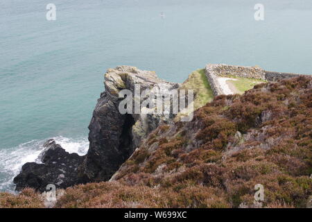 Robusto scogliera sul mare contro un mare verde smeraldo. St Agnes, North Cornwall, Regno Unito. Foto Stock