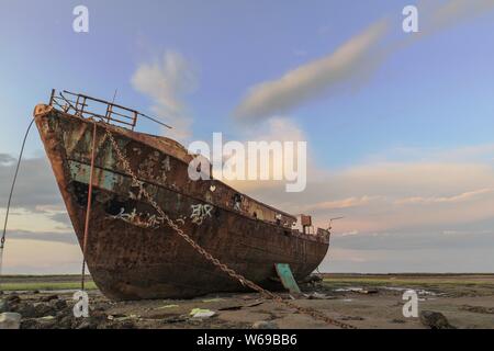 Rampside, Barrow-In-Furness, Cumbria, Regno Unito. 31 Agosto, 2019. Regno Unito Meteo. Dopo una giornata di sole e di docce, in tarda serata di sole e cielo blu da Rampside su la costa del Cumbria. Vista verso i derelitti peschereccio "Vita Nova' con nuvole sopra il lontano Morecambe Bay. Credito: greenburn/Alamy Live News Foto Stock