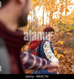 POV foto di un attraente caucasian escursionismo coppia attraverso il bosco in autunno in Canada Foto Stock