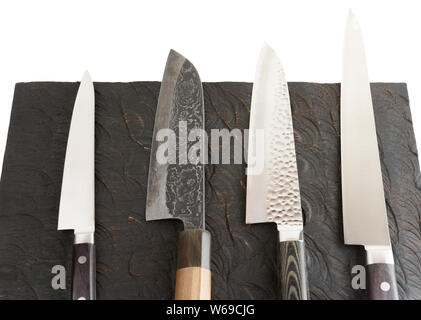 Impostare di nuovo e usato coltelli nero su pannello di legno Foto Stock