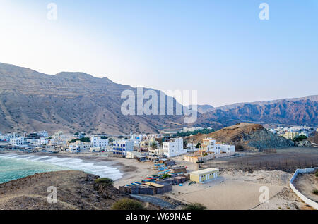 Un piccolo villaggio di pescatori sulla spiaggia ai piedi delle colline. Da Muscat Oman. Foto Stock