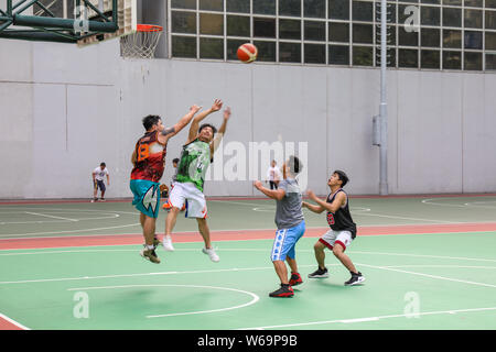 Hongkongers maschio giocare a basket su Southorn Playground a Wan Chai, Hong Kong Foto Stock