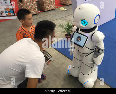 Ai visitatori di interagire con un ai robot durante il XVI (Cina) Wuhan International Auto Aftermarket mostra nella città di Wuhan, Cina centrale della provincia di Hubei, 23 Foto Stock