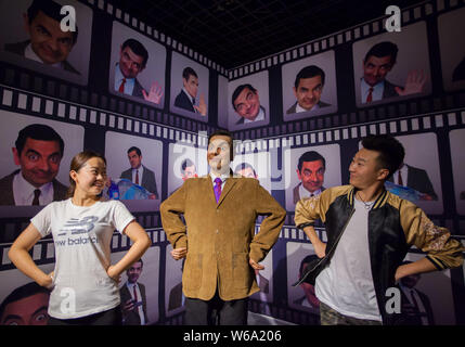 Visitatori posano per le foto con una cera la figura del signor Bean svolto dall'attore inglese Rowan Atkinson nel sitcom 'Mr. Fagiolo" in occasione di una nuova cera figura museum in H Foto Stock