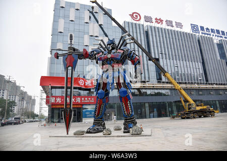 Una replica di Optimus Prime fatta di scarti di automobile è raffigurato nella parte anteriore di un complesso commerciale in Liaocheng city, est della Cina di Shandong provinc Foto Stock