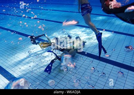 In questa foto non datata, i membri di un sottomarino di squadra di hockey di prendere parte a una sessione di formazione presso una piscina in Cina a Shanghai. Hockey subacqueo Foto Stock