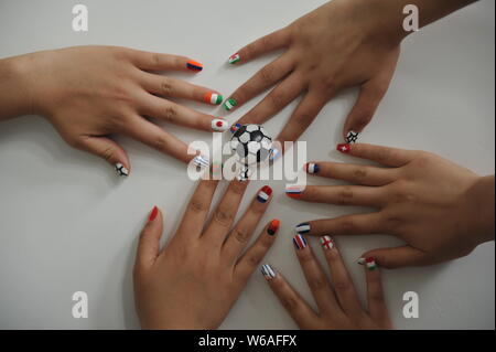 Donne tifose di calcio mostrano il loro Nail art design ispirato dalla 2018 FIFA World Cup in Liaocheng city, est della Cina di provincia di Shandong, 11 giugno 2018. Foto Stock