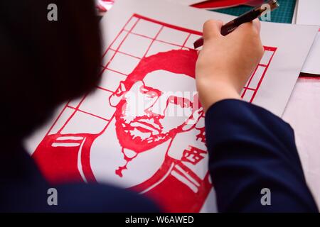 Uno studente di scuola senior scolpisce la carta in un opera d arte del ritratto di Argentina football player Lionel Messi a riscaldare il prossimo 2018 FIFA Wo Foto Stock