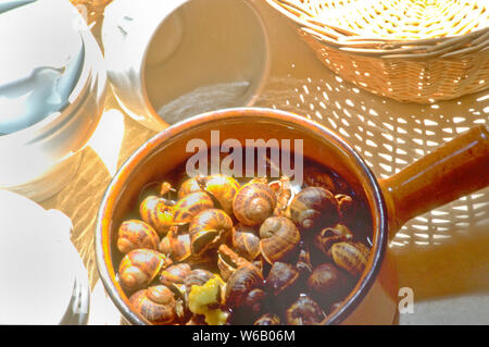 Escargots, considerata la delicatezza e un sofisticato antipasto, sono lumache di terra cotta nel burro all'aglio, vino e erbe aromatiche. Si tratta di un fiocco in Francia. Foto Stock