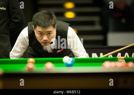 --FILE--Ding Junuhi della Cina ritiene un colpo a Judd Trump di Inghilterra nel loro quarto di partita finale durante il 2018 D88 tedesco Masters snooker tournam Foto Stock