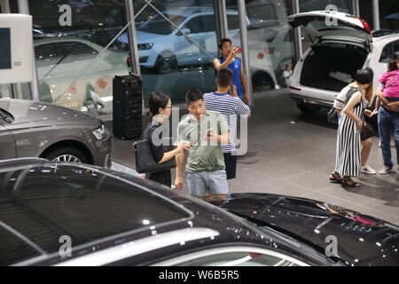 Gli acquirenti cinesi shop per vetture Audi presso un concessionario durante la notte prima di Hainan acquisto auto politica di restrizione prende effetto nel centro della città di Haikou, sud della Cina di Foto Stock