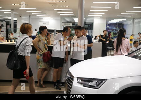 Gli acquirenti cinesi shop per vetture Audi presso un concessionario durante la notte prima di Hainan acquisto auto politica di restrizione prende effetto nel centro della città di Haikou, sud della Cina di Foto Stock