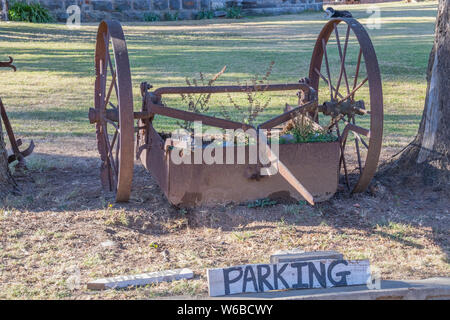 Vintage farm equipment parcheggiato all'ombra di alberi immagine in formato orizzontale Foto Stock