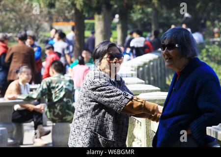 --FILE--anziani locali chat persone come loro riposo a un parco nella città di Lushan, Cina orientale della provincia di Jiangxi, 10 ottobre 2012. Il termine 'anziani drifters" Foto Stock