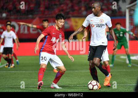 Calcio ecuadoriana player Jaime Ayovi, destro di Pechino Renhe calci la palla per effettuare un sorpasso ai danni di un giocatore di Henan Jianye nel loro decimo round mat Foto Stock