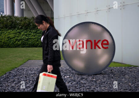 --FILE--A passeggiate a piedi passato un logo di Vanke nella città di Shenzhen, Cina del sud della provincia di Guangdong, 19 aprile 2018. Proprietà cinese carta pesante Foto Stock