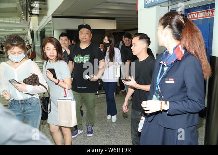 Corea del Sud la cantante e attrice Bae Suzy, meglio conosciuto dal mononym Suzy, centro, è circondato da una folla di tifosi ad Hong Kong International Air Foto Stock