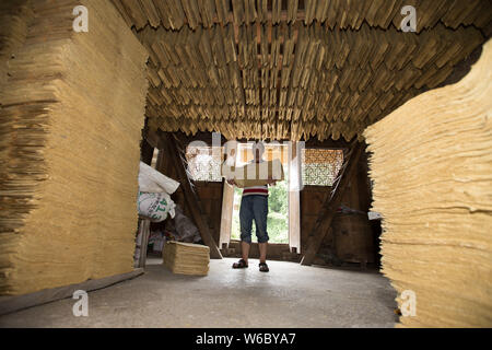 Artigiano cinese Hu Zongliang rende joss carta fatta di fibra di bambù in modo tradizionale presso la sua bottega in borgo Xiangzhigou, Wudang distretto, Guiya Foto Stock