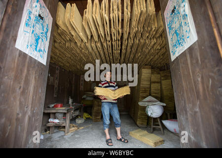 Artigiano cinese Hu Zongliang rende joss carta fatta di fibra di bambù in modo tradizionale presso la sua bottega in borgo Xiangzhigou, Wudang distretto, Guiya Foto Stock