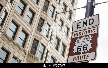 Route 66 Illinois iniziare cartello stradale a Chicago downtown della città. La facciata degli edifici dello sfondo. Route 66, madre road, il classico roadtrip storico NEGLI STATI UNITI Foto Stock