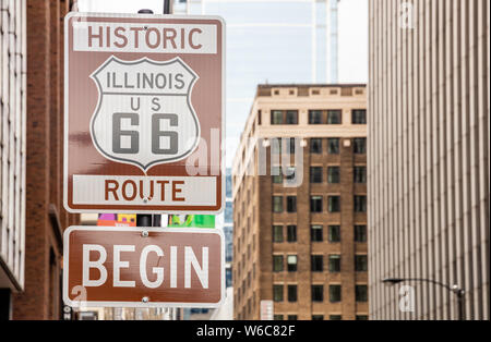 Route 66 Illinois iniziare cartello stradale a Chicago downtown della città. La facciata degli edifici dello sfondo. Route 66, madre road, il classico roadtrip storico NEGLI STATI UNITI Foto Stock
