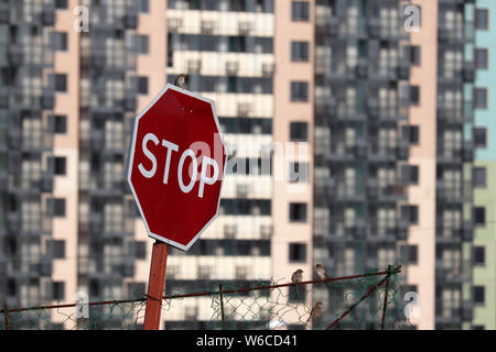 Il segnale di arresto sull'edificio residenziale di sfondo, l'ingresso è vietato. Concetto di area chiusa, sicurezza, sito in costruzione Foto Stock