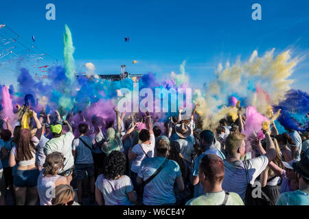 Centinaia di giovani stanno celebrando Holi il Festival di colori, gettare polvere di colore in aria Foto Stock