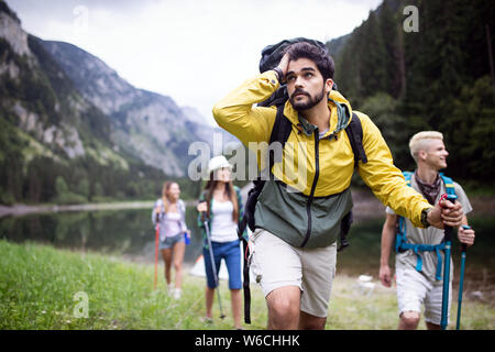 Trekking, campeggio, escursioni e la vita selvatica concetto. Gruppo di amici sono gite nella natura Foto Stock