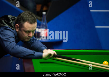 Stephen Maguire della Scozia gioca un colpo a Ronnie O'Sullivan dell'Inghilterra in il loro match di primo turno durante il 2018 Betfred World Snooker Championship Foto Stock