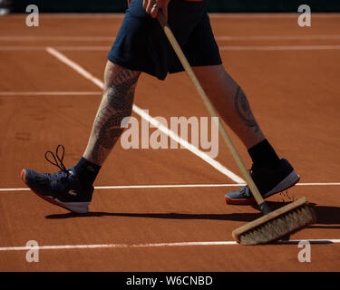 Sezione bassa del lavoratore linea pulizia del campo da tennis con una scopa durante il French Open 2019, Parigi, Francia Foto Stock