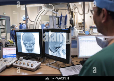 A Clermont-Ferrand (Francia centrale). Reparto di Radiologia dell' ospedale universitario. Radiologo conducendo una angiografia nell'imaging interventistico ro Foto Stock