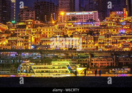 --FILE--vista notturna dell'illuminato Hongyadong risolte complesso di case nel distretto di Jiangbei, Chongqing, la Cina, il 6 aprile 2018. Scene di sera a Chong Foto Stock