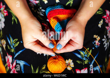 Le mani delle donne crochet. Fatti a mano, ricamo e hobby. Close-up, vista dall'alto. Foto Stock