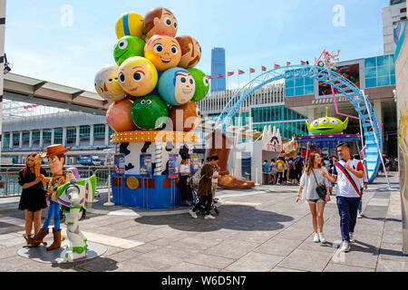 Hong Kong, Cina. 26 Luglio, 2019. Una donna possiede accanto alle repliche dello sceriffo Woody e Buzz Lightyear durante il carnevale.Toy Story 4 è celebrato con un carnevale a tema di diversi giochi e sfide da Hong Kong Harbour City e Disney di Hong Kong, Cina. Credito: Daniel Fung SOPA/images/ZUMA filo/Alamy Live News Foto Stock