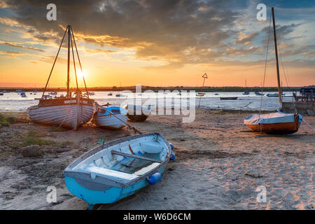 Bel tramonto su barche sulla spiaggia a West Mersea, una piccola isola di marea off Essex coast Foto Stock